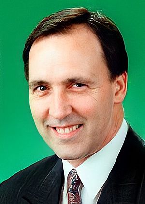 Keating smiling in front of a green background
