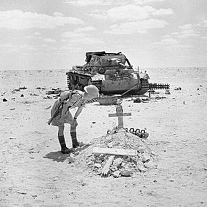 A British soldier inspects the grave of a German tank crewman, killed when his PzKpfw III tank was knocked out in the Western Desert, 29 September 1942. E17549