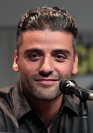 Oscar Isaac is sitting before a mic