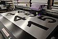 Large Format Printing of Black Numbers on a Brushed Aluminum Sheet