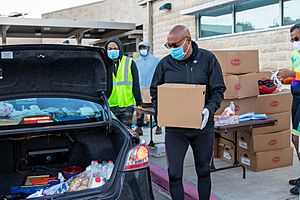 Ellis loads food from the Houston Food Bank during a giveaway for people suffering during the COVID 19 pandemic