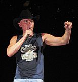 Country music singer Kenny Chesney holding a microphone